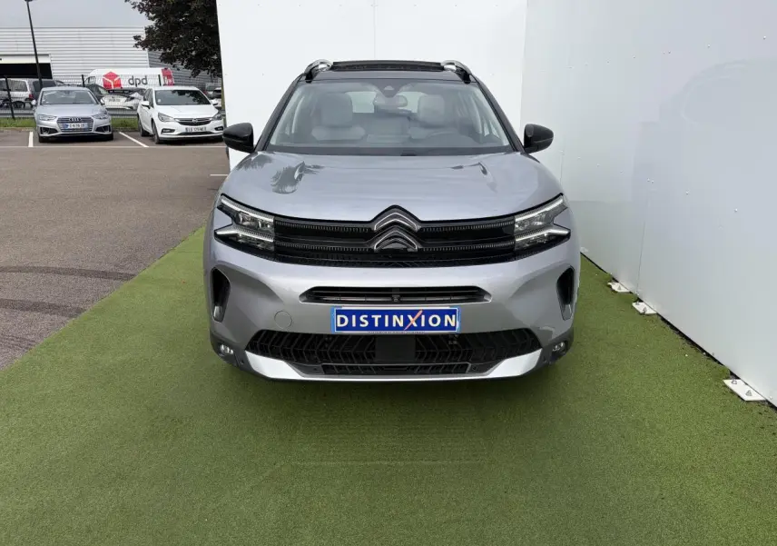 Vue avant d'un Citroën C5 Aircross gris métal avec toit panoramique et calandre noir brillant.