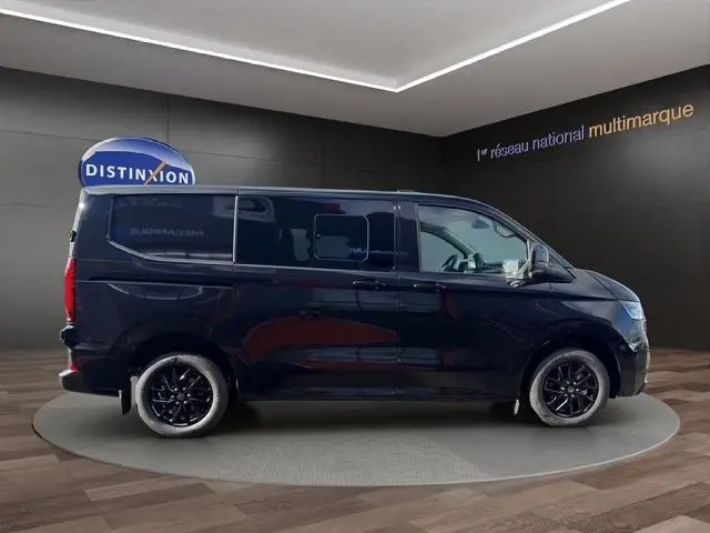 Vue de profil droit du Volkswagen Transporter noir 2026, finition Business, avec jantes noires et vitres teintées.