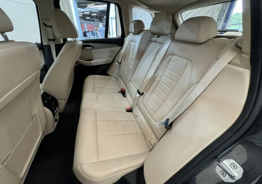 Vue intérieure côté droit des sièges arrière en cuir beige du BMW X3 xDrive30d gris foncé de 2018.