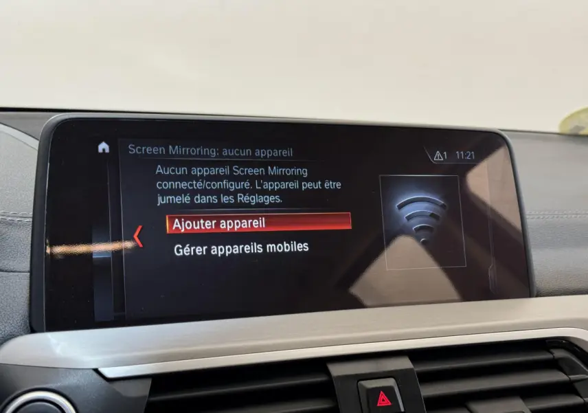 Vue intérieure du tableau de bord BMW X3 gris foncé 2018, écran tactile affichant menu de connexion mobile.