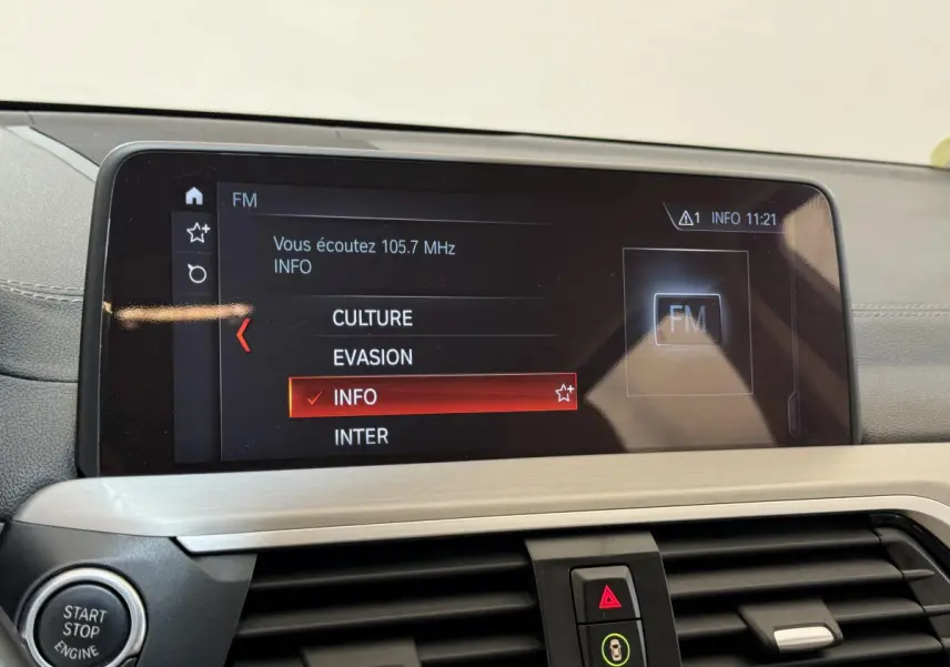 Écran tactile central affichant la radio FM dans l'habitacle gris clair d'une BMW X3 xDrive30d 2018