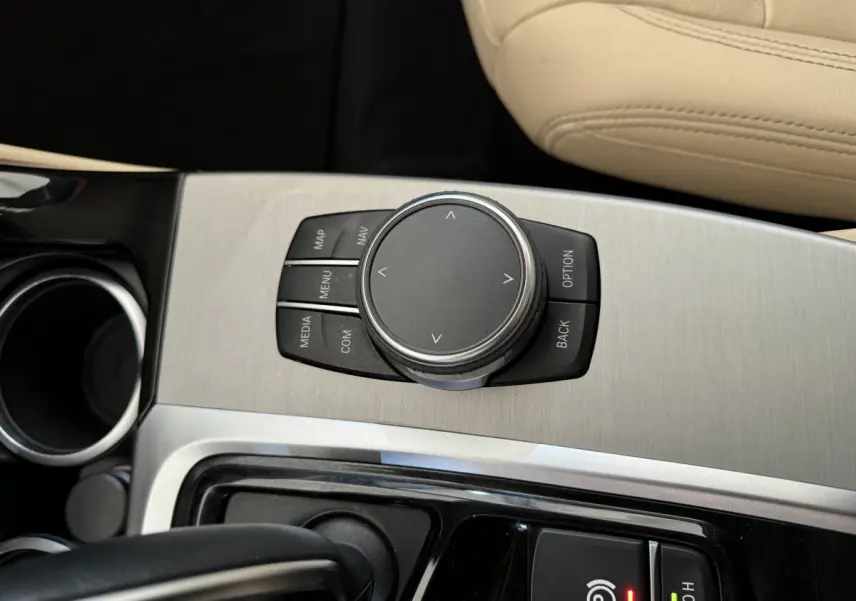 Gros plan sur la molette de commande iDrive et console centrale en aluminium brossé du BMW X3 gris foncé 2018 Luxury.