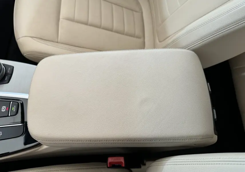 Gros plan sur l'accoudoir central beige et les sièges en cuir clair de l'intérieur du BMW X3 xDrive30d 2018.