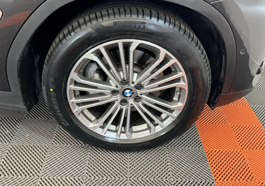 Gros plan sur la roue avant droite gris foncé d’un BMW X3 xDrive30d 2018 avec jante multibranches et pneu Pirelli.