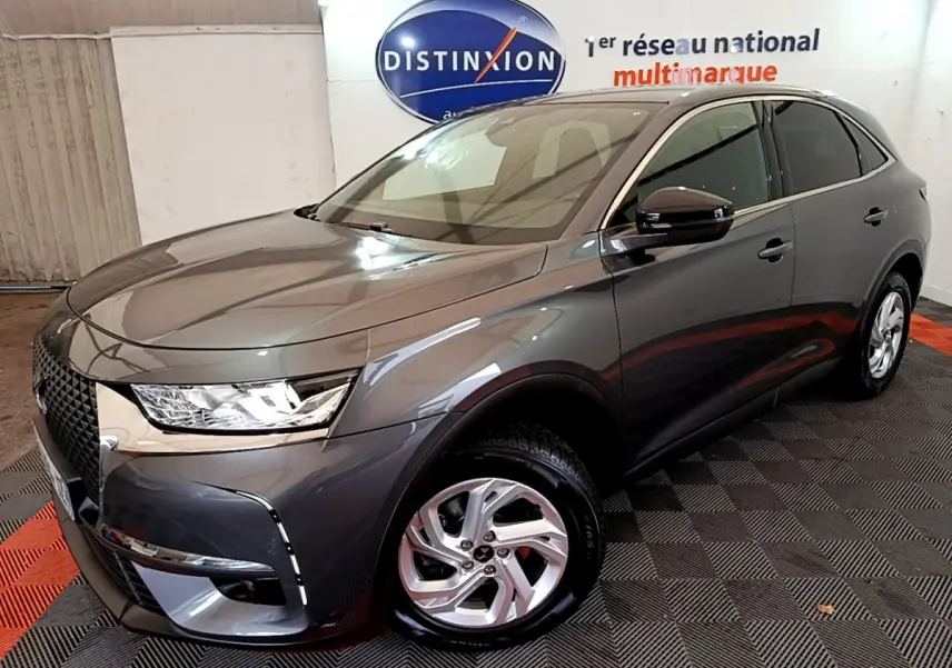 DS7 Crossback gris foncé vu en 3/4 avant droit, mettant en valeur sa calandre distinctive et ses phares LED.