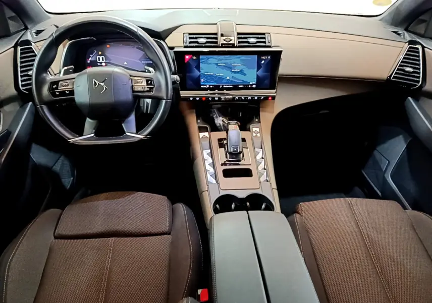 Vue intérieure avant du DS7 Crossback 2020 avec tableau de bord beige, écran tactile central et volant cuir noir.
