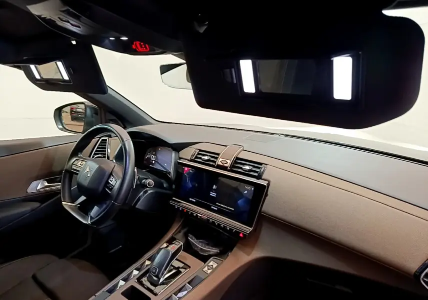 Intérieur du DS7 Crossback gris foncé vu côté conducteur, tableau de bord moderne avec écran tactile 12 pouces allumé.