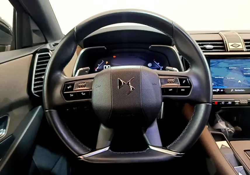 Vue intérieure centrée sur le volant cuir noir du DS7 Crossback 2020, avec tableau de bord numérique et écran tactile visible.