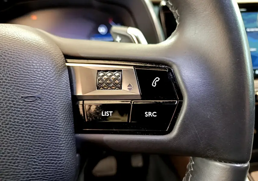 Gros plan sur les commandes gauche du volant cuir noir du DS7 Crossback 2020, boutons LIST, SRC et téléphone.