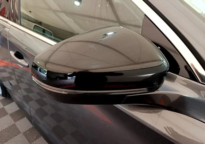 Rétroviseur noir brillant côté conducteur d'un DS7 Crossback gris foncé, vue rapprochée sur la portière avant.