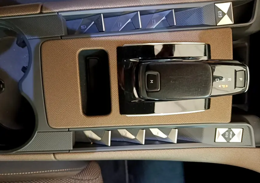 Vue rapprochée de la console centrale du DS7 Crossback 2020, avec levier de vitesses automatique et boutons de contrôle noirs et marron.
