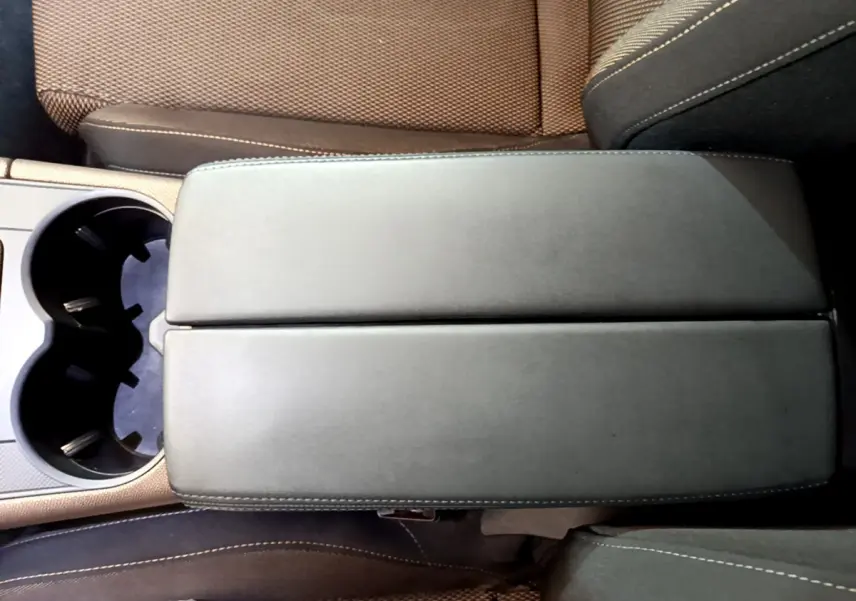 Vue plongeante sur l'accoudoir central en cuir noir et les sièges marron du DS7 Crossback 2020.