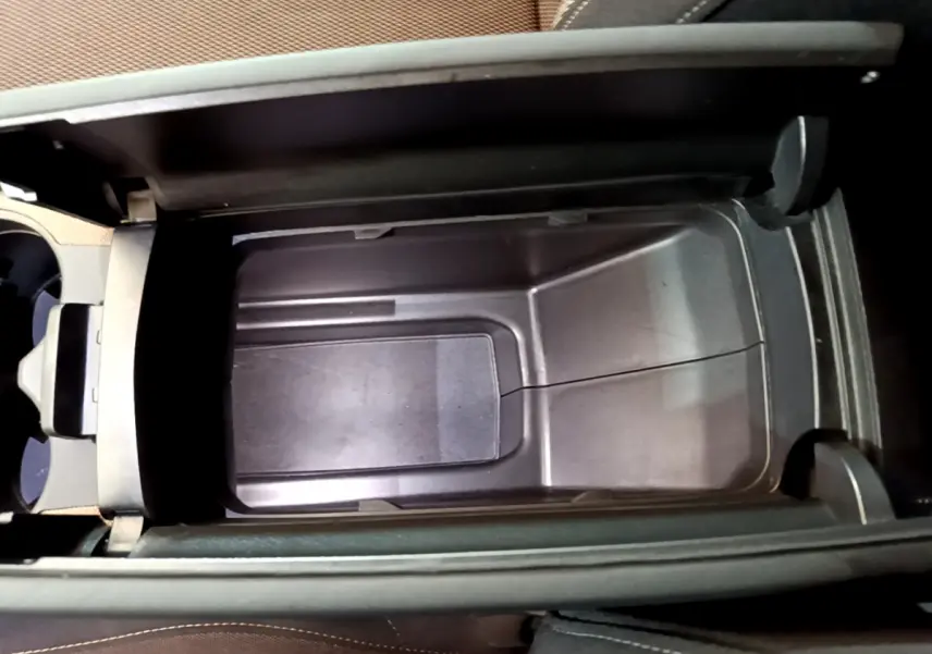 Vue plongeante sur le rangement central ouvert du DS7 Crossback Business 2020, intérieur noir et tissu marron.