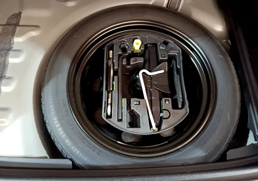 Vue en plongée sur la roue de secours et ses outils dans le coffre du DS7 Crossback gris foncé de 2020.
