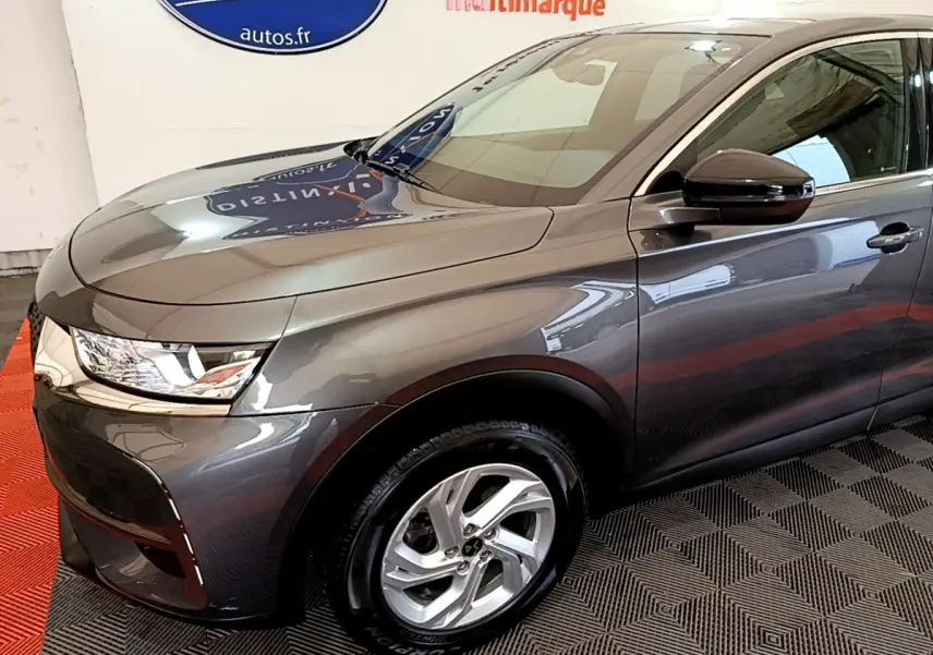 Vue 3/4 avant droit d’un DS7 Crossback gris foncé avec jantes alliage et rétroviseur noir brillant.