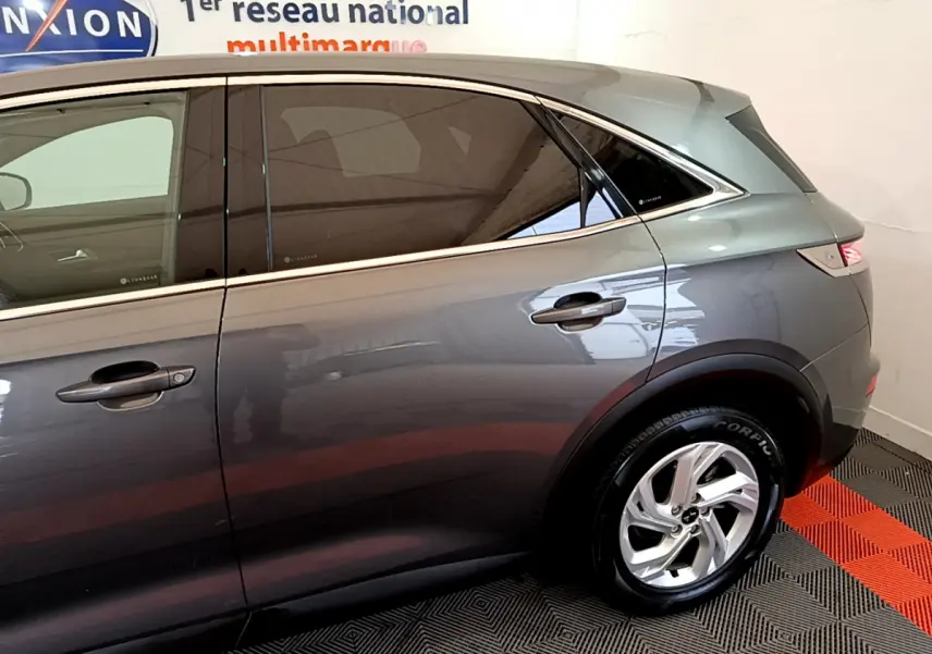 Vue latérale droite du DS7 Crossback gris foncé, mettant en valeur les vitres teintées et les jantes alliage.