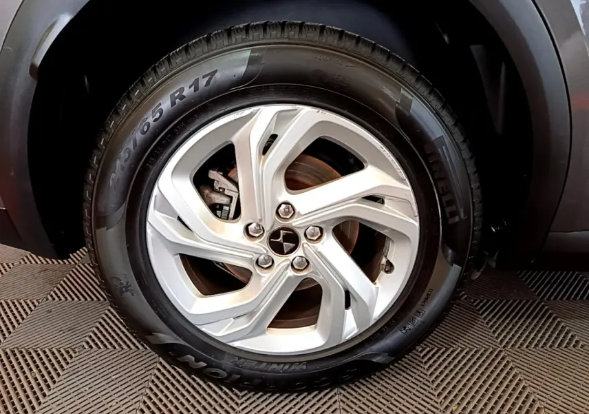 Gros plan sur la roue avant droite d’un DS7 Crossback gris foncé, mettant en valeur le pneu Pirelli et l’arche de roue.