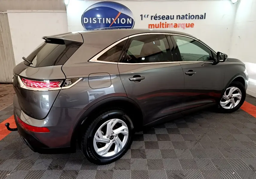 Vue 3/4 arrière droite du DS7 Crossback gris foncé avec feux arrière LED et jantes alliage cinq branches.