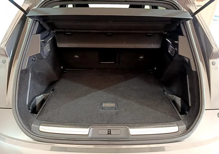 Vue arrière du coffre ouvert du DS7 Crossback gris foncé, montrant un espace de chargement spacieux et bien fini.