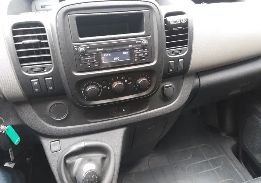 Tableau de bord et console centrale du Renault Trafic Microbus 2016, vue intérieure côté passager, volant absent.