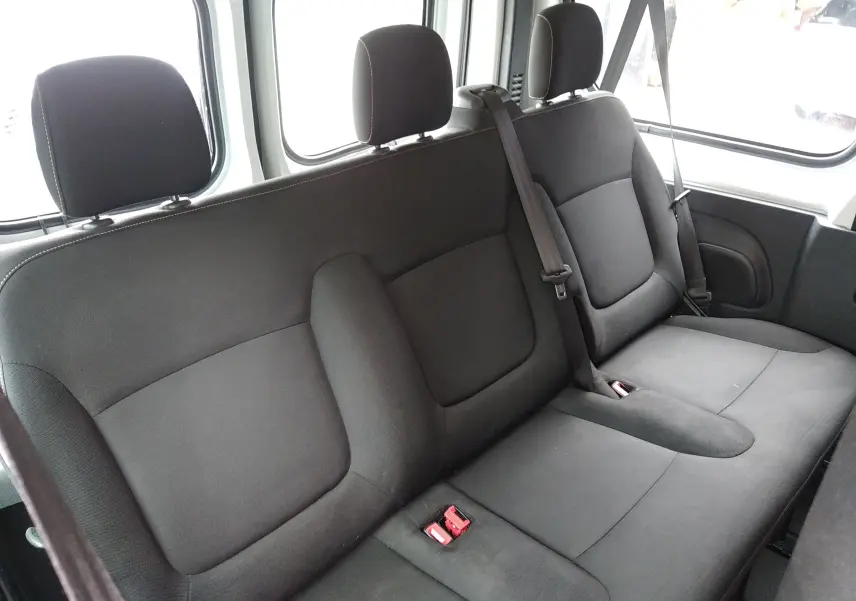 Banquette arrière en tissu noir vue de côté gauche dans un Renault Trafic Microbus blanc de 2016.