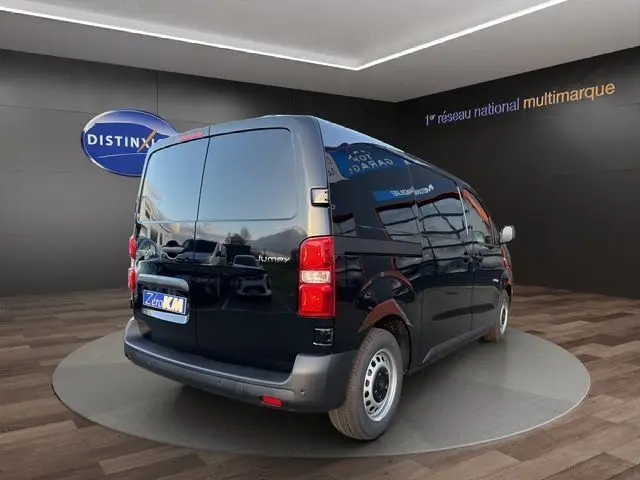 Vue 3/4 arrière droite d’un Citroën Jumpy noir Perla Nera, fourgon utilitaire avec portes arrière battantes et jantes acier.
