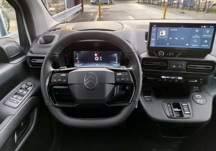 Vue intérieure centrée sur le volant et le tableau de bord numérique du Citroën Berlingo 2025, finition noire.