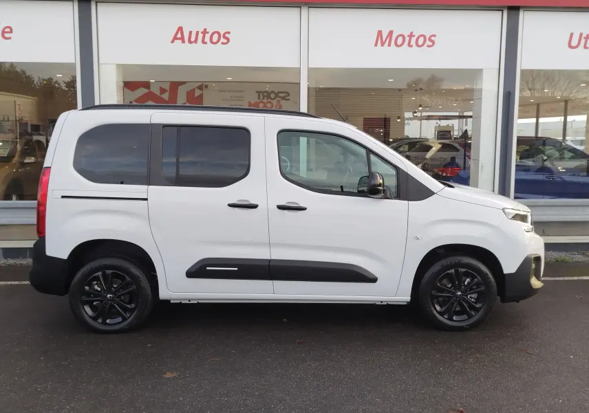 Vue de profil côté droit d'un Citroën Berlingo blanc Kaolin avec jantes noires et protections latérales noires.