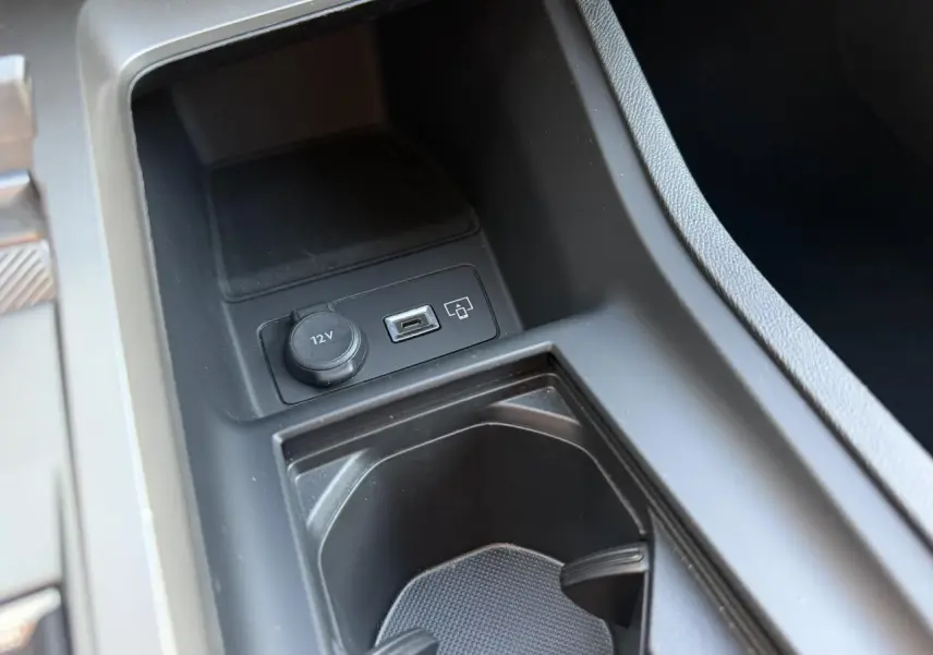 Gros plan sur la console centrale noire avec prise USB-C et prise 12V dans une Peugeot 308 2025.