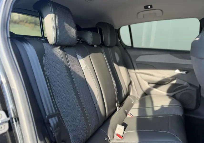 Vue latérale gauche des sièges arrière en tissu et cuir noir de la Peugeot 308 2025, avec ceinture de sécurité visible.