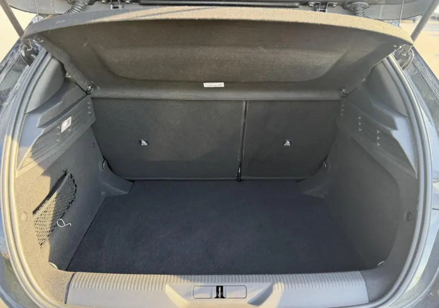 Coffre ouvert de la Peugeot 308 noir Perla, vue arrière montrant l'espace de chargement vide et les finitions intérieures.