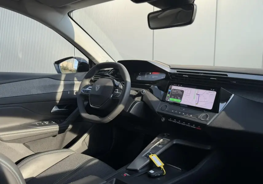 Vue intérieure côté conducteur du Peugeot 308 2025 noir Perla, avec tableau de bord numérique et écran tactile central.