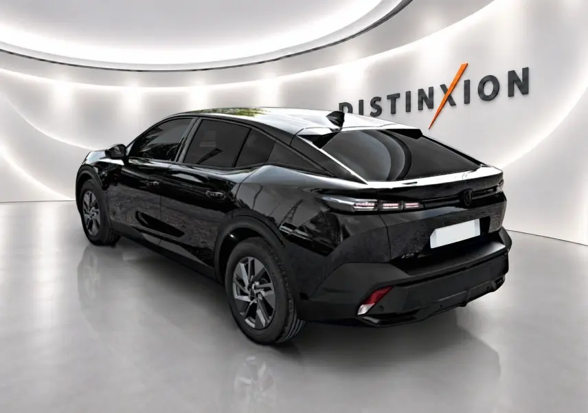 Vue 3/4 arrière droite d'une Peugeot 408 Hybrid 136 allure e-dcs6 noire avec vitres surteintées en showroom lumineux.