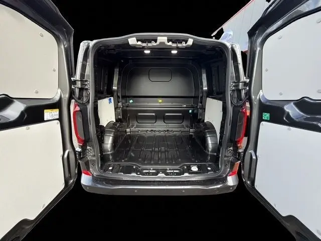 Vue arrière du Volkswagen Transporter gris foncé 2026 avec portes arrière ouvertes et espace de chargement vide.