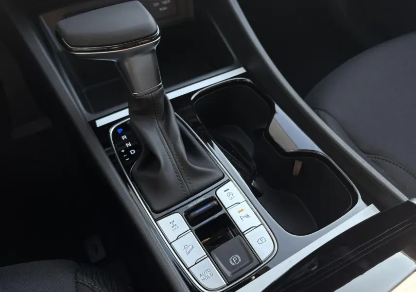 Gros plan sur la console centrale du Hyundai Tucson 2025 avec levier de vitesse automatique et commandes de stationnement.