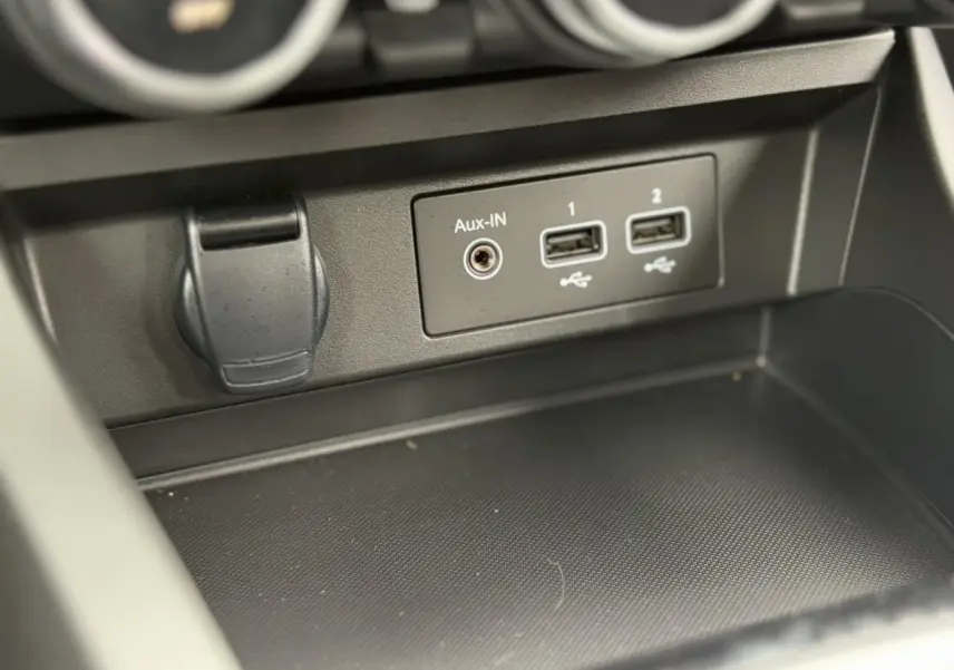 Vue rapprochée du compartiment central avec prises USB et entrée Aux-In du Renault Arkana noir métal 2024.