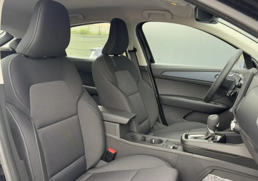 Vue intérieure côté droit du Renault Arkana E-Tech Full Hybrid 145 Evolution 2024, sièges tissu noir avec accoudoir central.
