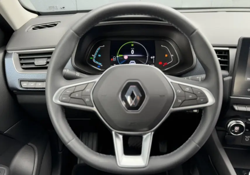 Vue rapprochée du volant Renault Arkana E-Tech 2024 avec tableau de bord numérique et commandes intégrées.