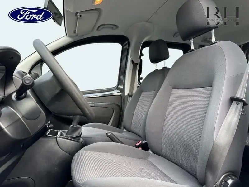 Vue intérieure côté conducteur du Citroën Nemo gris Graphito de 2013, montrant les sièges tissu et la boîte manuelle.