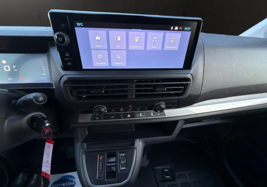 Tableau de bord central et écran tactile du Citroën Jumpy noir, vue intérieure frontale sur la console et commandes.