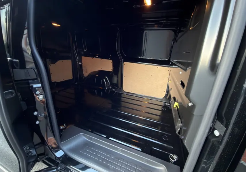 Vue intérieure arrière droite du Citroën Jumpy noir 2026 montrant l’espace de chargement avec cloison pleine.