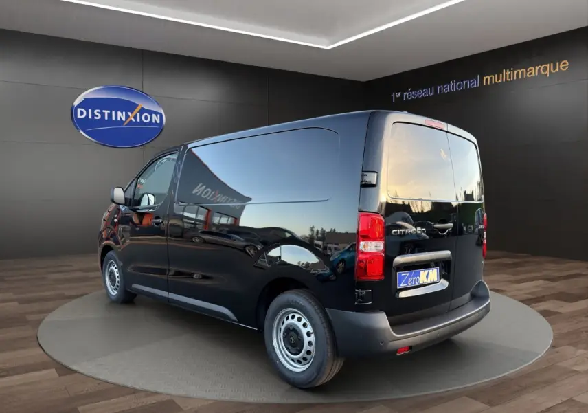 Vue 3/4 arrière droite d’un Citroën Jumpy noir avec hayon fermé, roues acier et logo visible sur fond showroom.