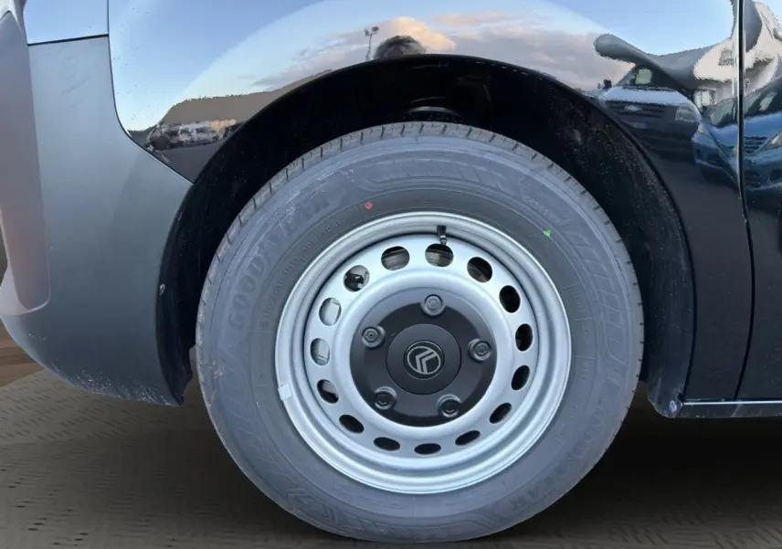 Gros plan sur la roue avant droite d’un Citroën Jumpy noir avec jante acier et pneu Goodyear.