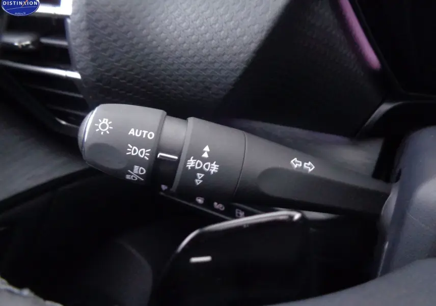 Gros plan sur la commande des phares et clignotants du Citroën C5 X 1.6 Hybrid 225 Shine noir métal, intérieur sombre.