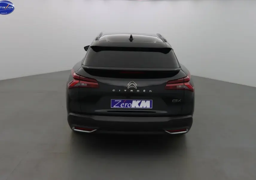 Vue arrière d'une Citroën C5 X noire métal avec feux LED et vitrage arrière teinté dans un studio neutre.