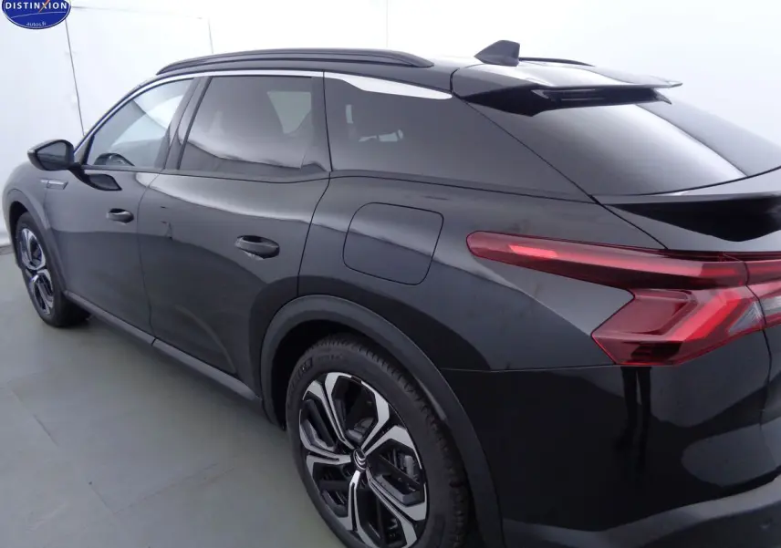 Vue 3/4 arrière côté gauche d'une Citroën C5 X noire métal avec feux arrière LED et jantes bi-ton.