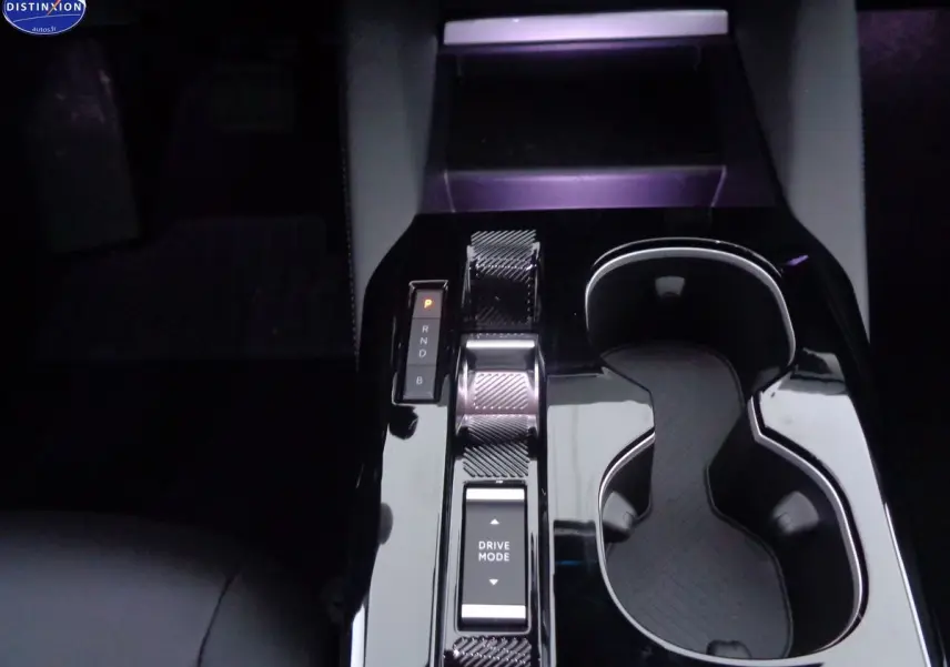 Gros plan sur la console centrale noire brillante de la Citroën C5 X hybride rechargeable avec sélecteur de mode de conduite.