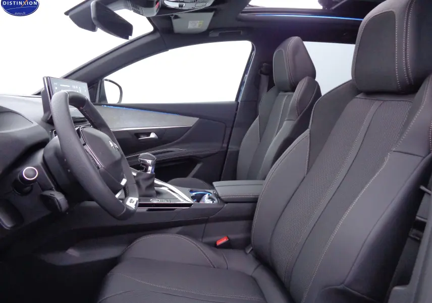Intérieur du Peugeot 3008 2023 vu côté conducteur, sièges cuir noir avec surpiqûres et toit panoramique ouvert.