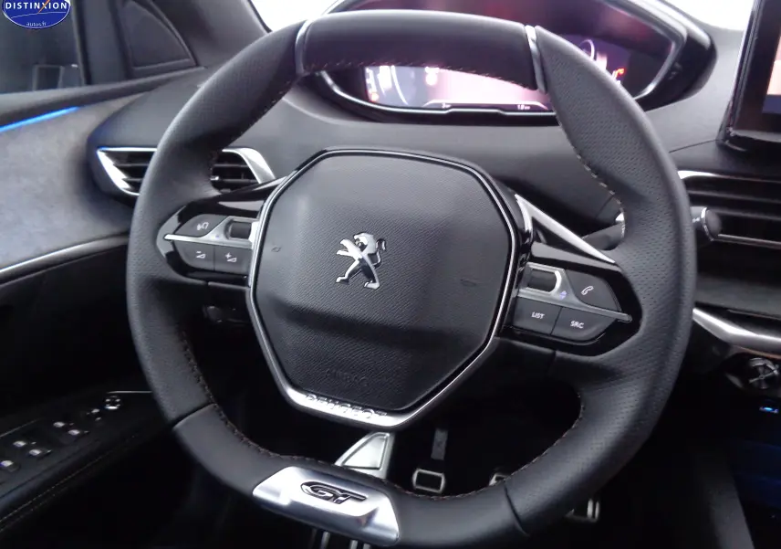 Volant cuir noir avec logo Peugeot et badge GT, vue rapprochée de l'intérieur du Peugeot 3008 2023.