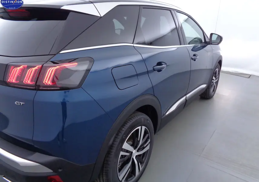 Vue 3/4 arrière droite d'un Peugeot 3008 GT bleu Célèbes Métal avec feux arrière LED distinctifs et jantes alliage bicolores.